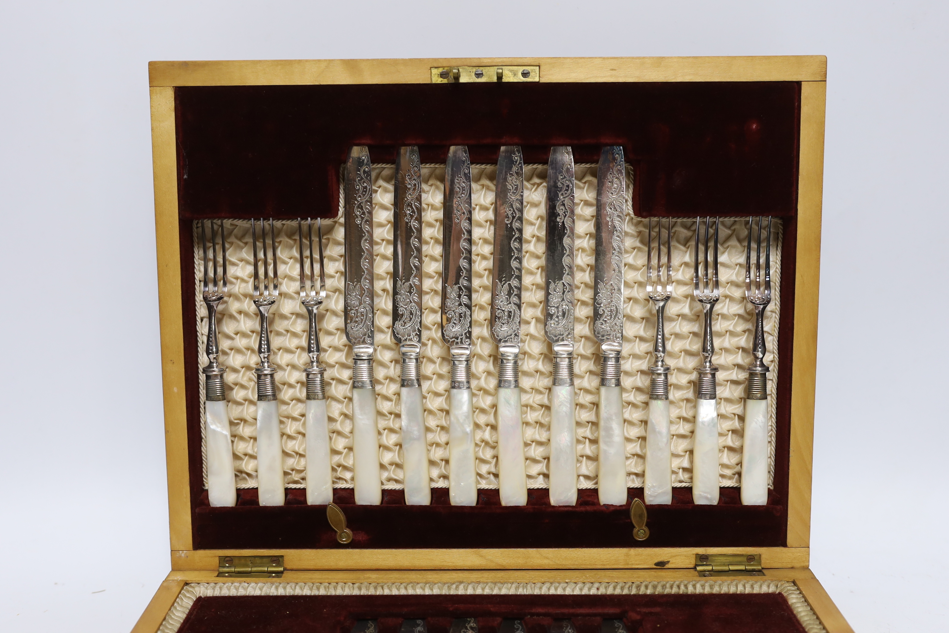 An Edwardian cased set of mother of pearl handled plated dessert knives and forks with silver collars, Sheffield 1901